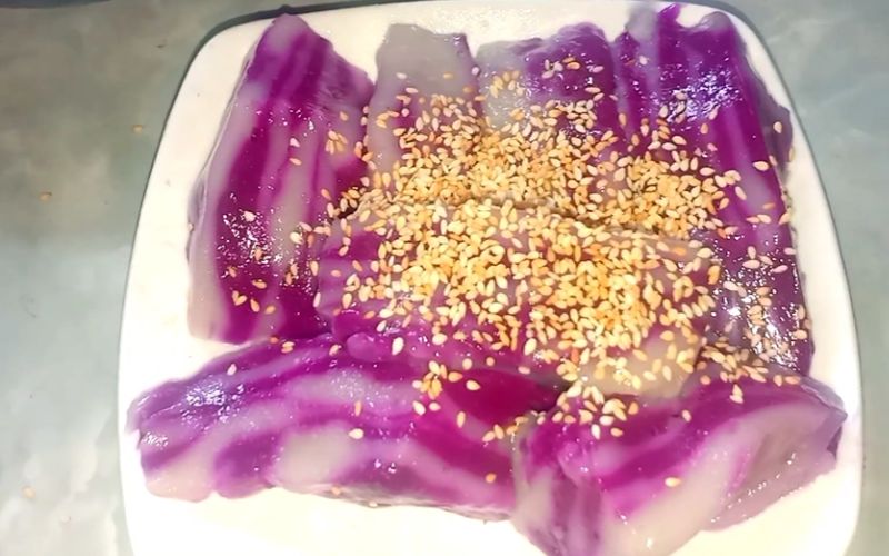 Món bánh đúc lá cẩm này thường được thưởng thức kèm với nước cốt dừa và mè rang