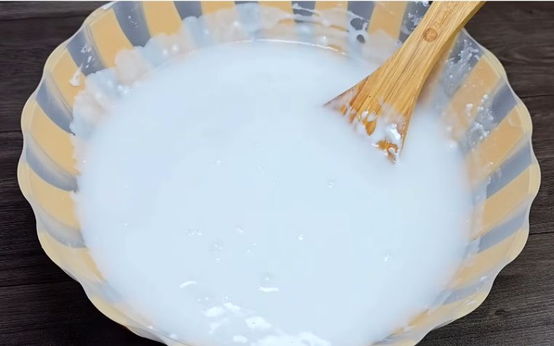Cho 500ml nước cốt dừa vào tô, khuấy đều để bột hòa quyện với nước